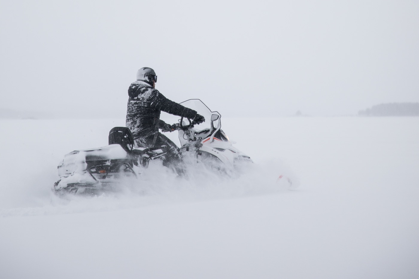 vue à travers des rafales de neige d'un motoneigiste